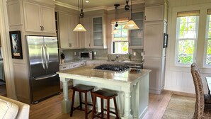A spacious kitchen with a large island, stainless steel appliances, and pendant lighting. - Admired Poipu beach house in a perfect location, now a vacation home! (Koloa)