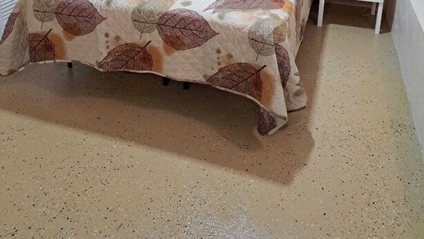 Una camera da letto con un letto, due comodini, un condizionatore d'aria e una finestra con tende.