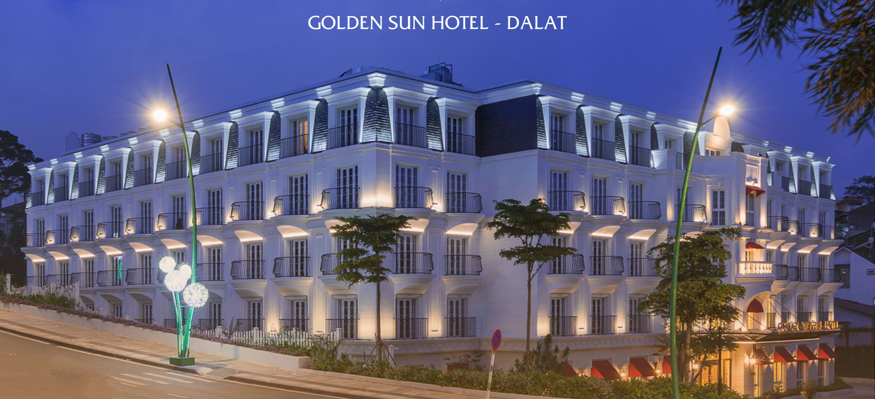 Ein mehrstöckiges Hotel mit symmetrischer Fassade, beleuchteten Fenstern und einer gepflegten Außenansicht.