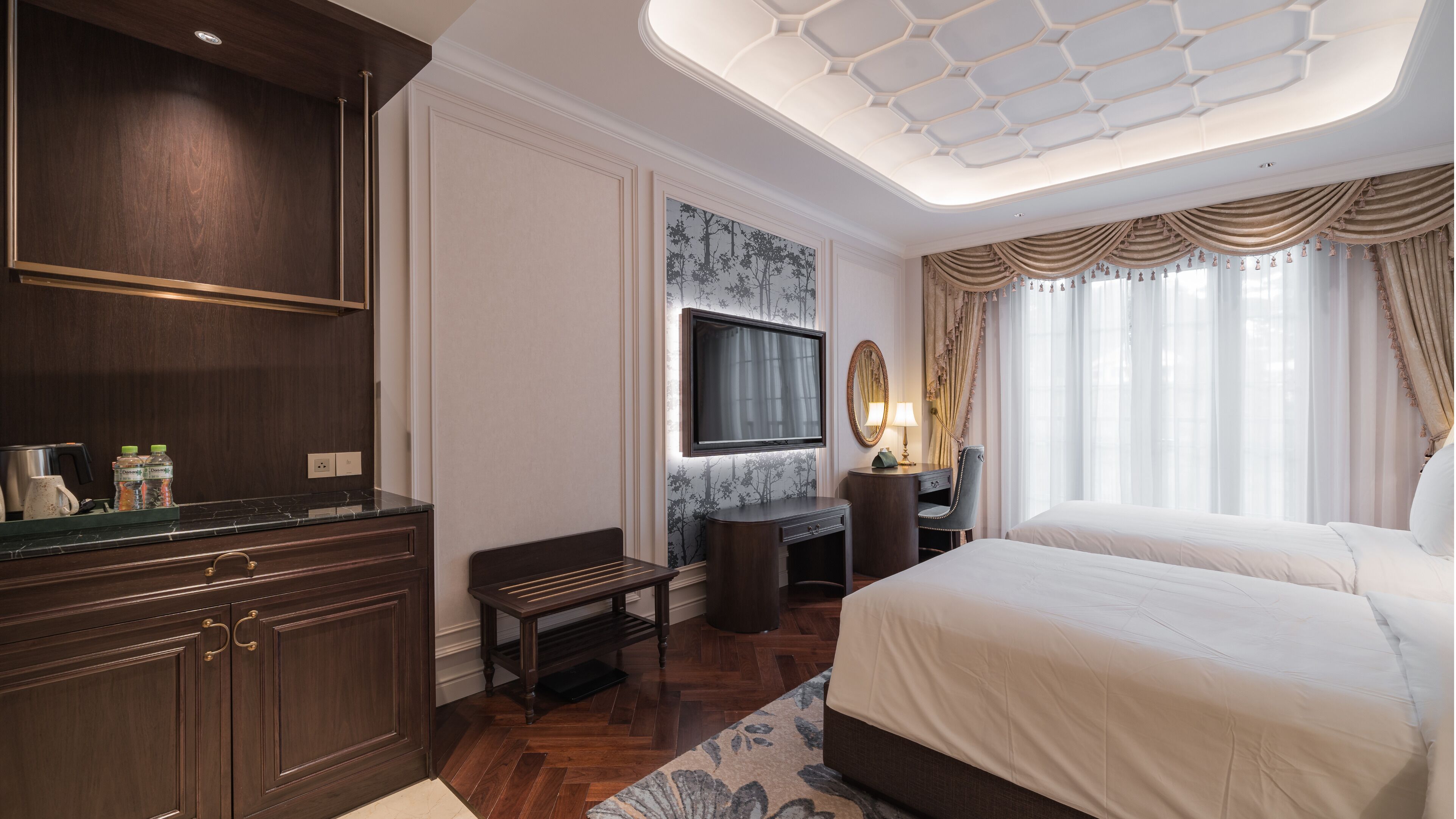 Ein Hotelzimmer mit einem großen Bett, einem Schreibtisch mit Stuhl, einem an der Wand befestigten Fernseher und einem Kleiderschrank.