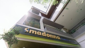 En byggnad med en skylt som föreställer en "Madonna", vilket indikerar att det är ett hotell eller liknande verksamhet.