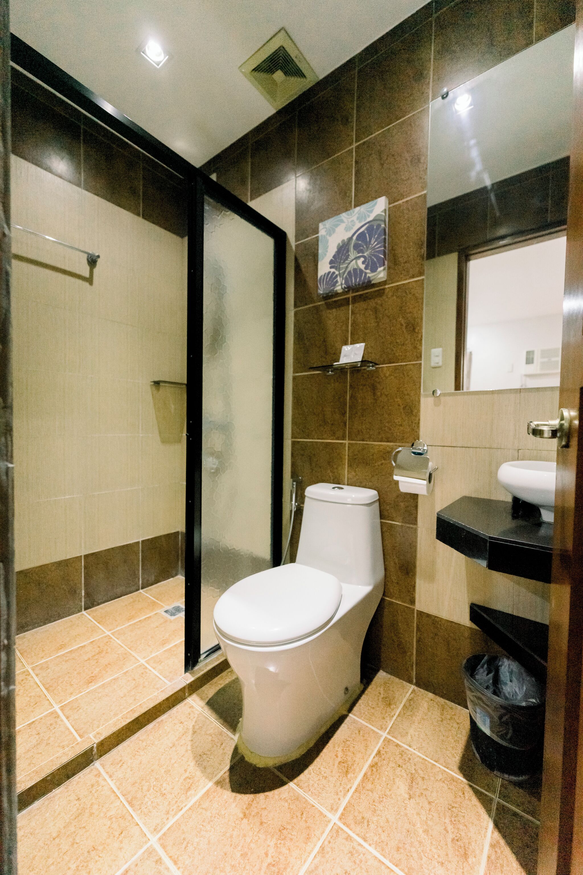 A modern bathroom with a toilet, sink, and shower area.