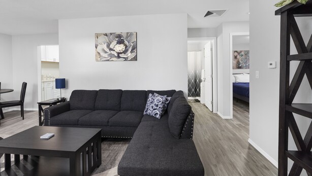 Ein modernes Wohnzimmer mit einem Ecksofa, einem Couchtisch und einem Gemälde an der Wand.
