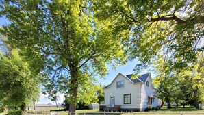 Il s’agit d’une propriété résidentielle dotée d’une cour clôturée, d’une maison avec un toit à pignon et d’une allée pavée.