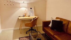 Ein modernes Wohnzimmer mit einem Holztisch, einem braunen Ledersofa und einem Glastisch.