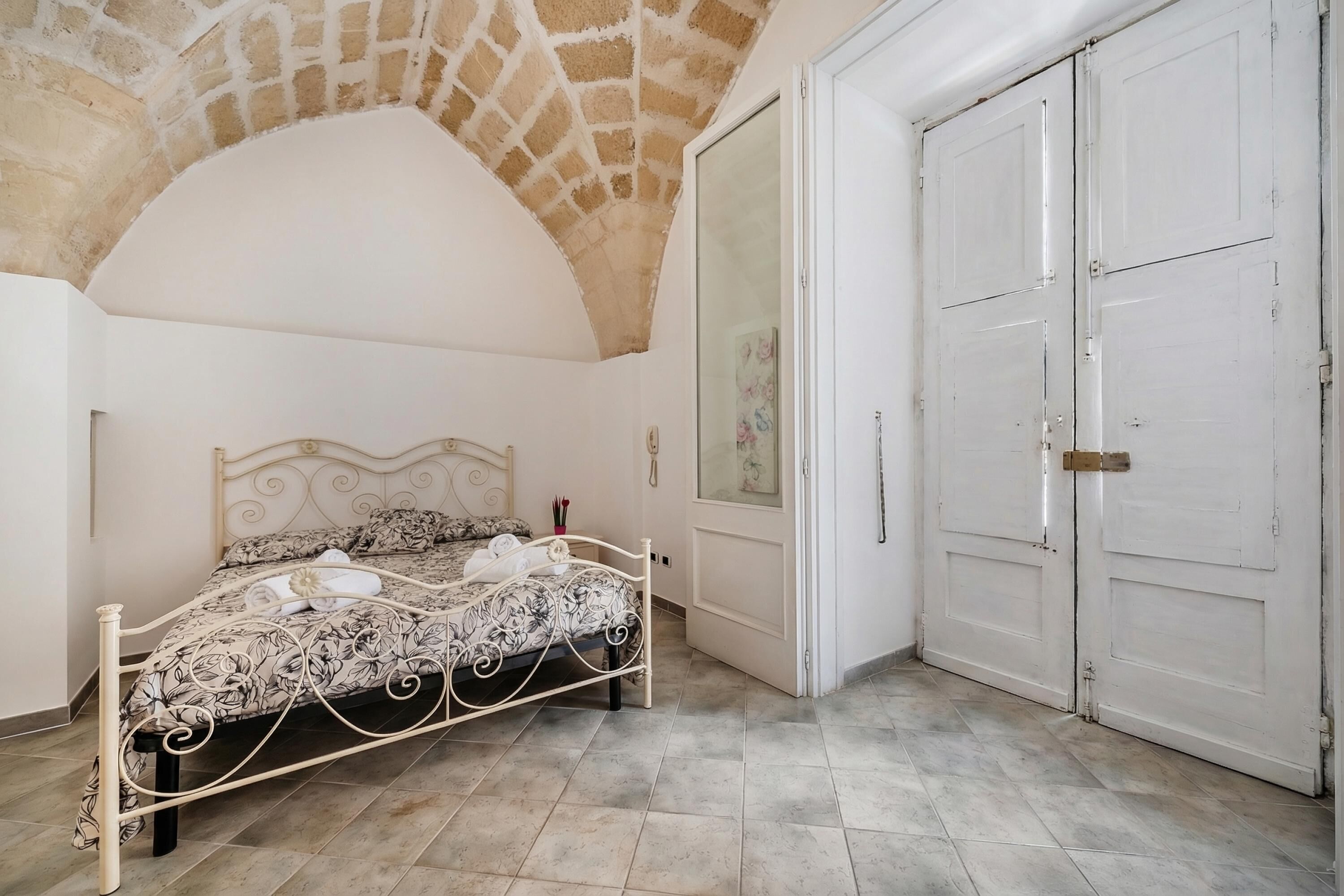 Une chambre à coucher avec un lit, une armoire et un plafond en forme d’arc en pierre.