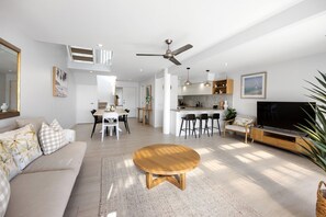 A modern living space with a dining area, kitchen, and seating area.