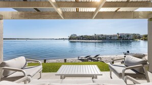 Un espacio de estar al aire libre techado con vistas a una playa y al mar.