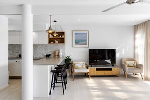 A modern living space with a kitchen, dining area, and seating. - Bellavista 3 - Riverfront with Beach (Noosaville)