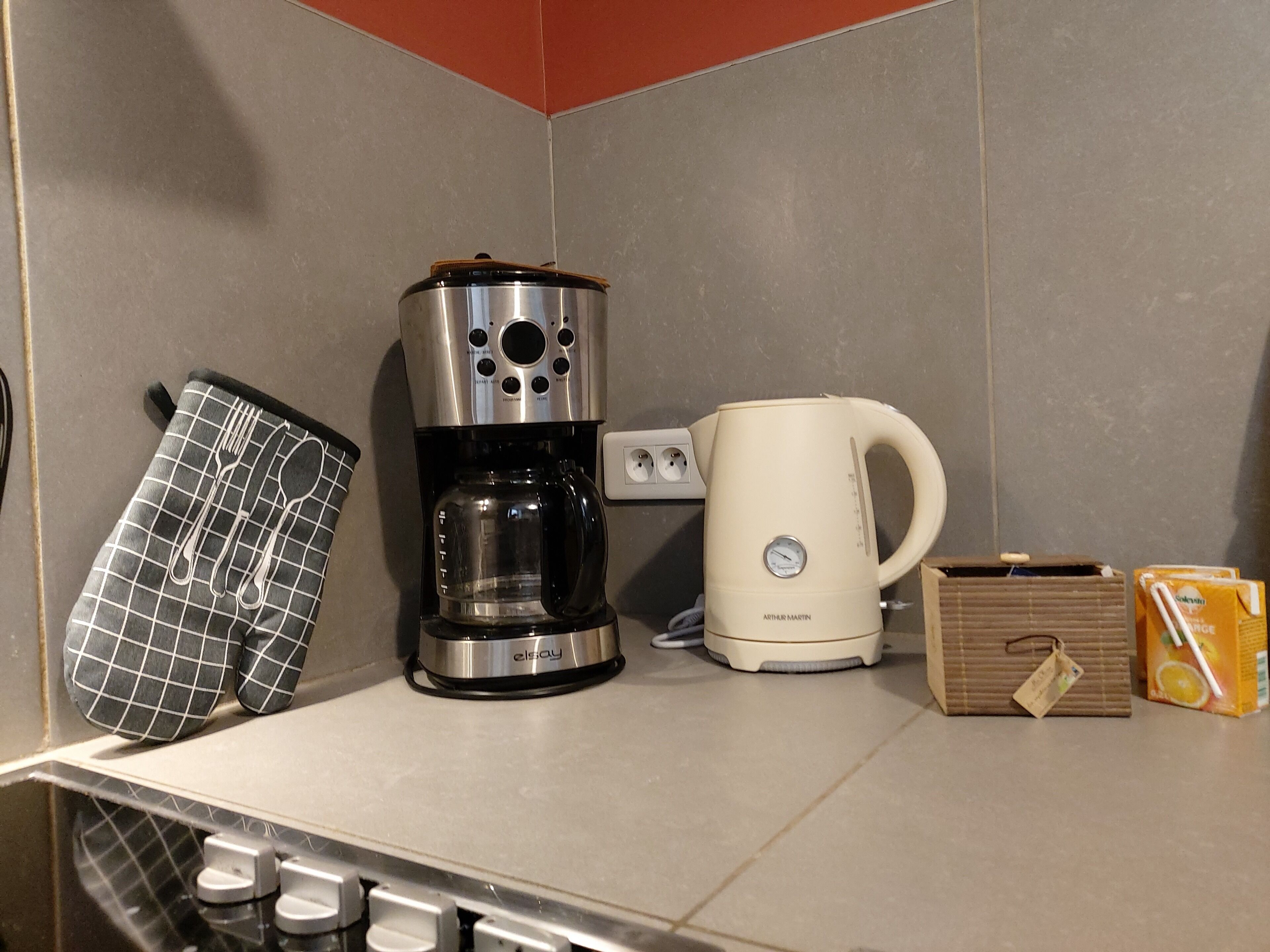 Eine Küche mit Kaffeemaschine, Wasserkocher und Orangensaft.