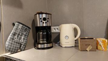Eine Küche mit Kaffeemaschine, Wasserkocher und Orangensaft.