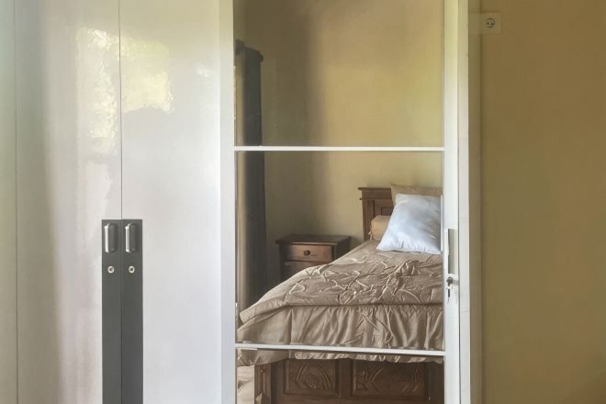 A bedroom with a bed, a nightstand, and a wardrobe.