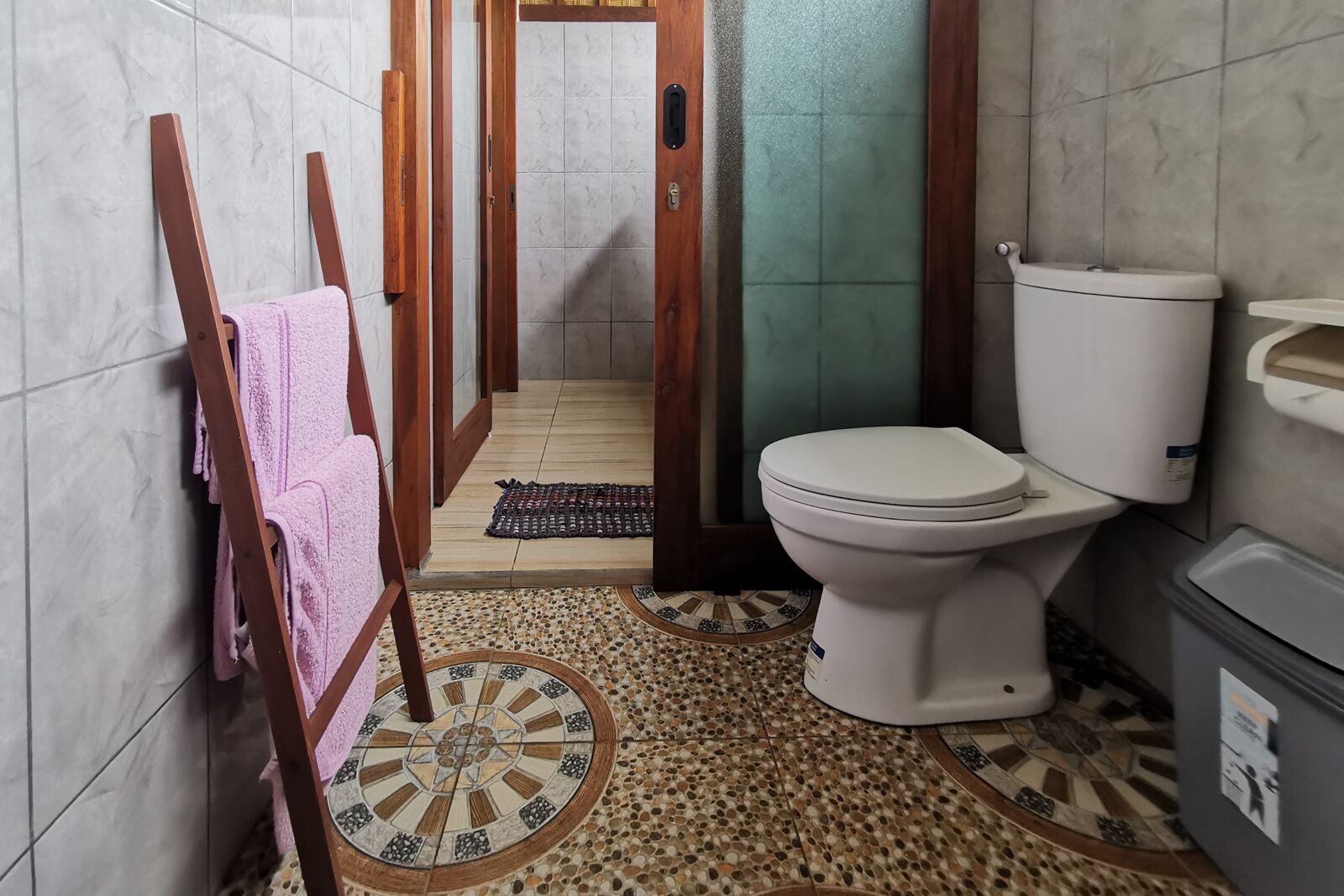 Un baño con inodoro, lavamanos y zona de ducha.