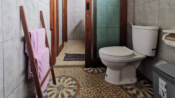 Un baño con inodoro, lavamanos y zona de ducha.
