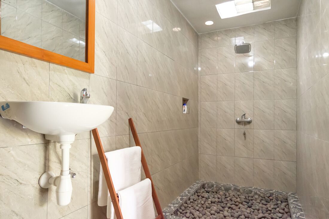 A bathroom with a white sink, mirror, and shower.