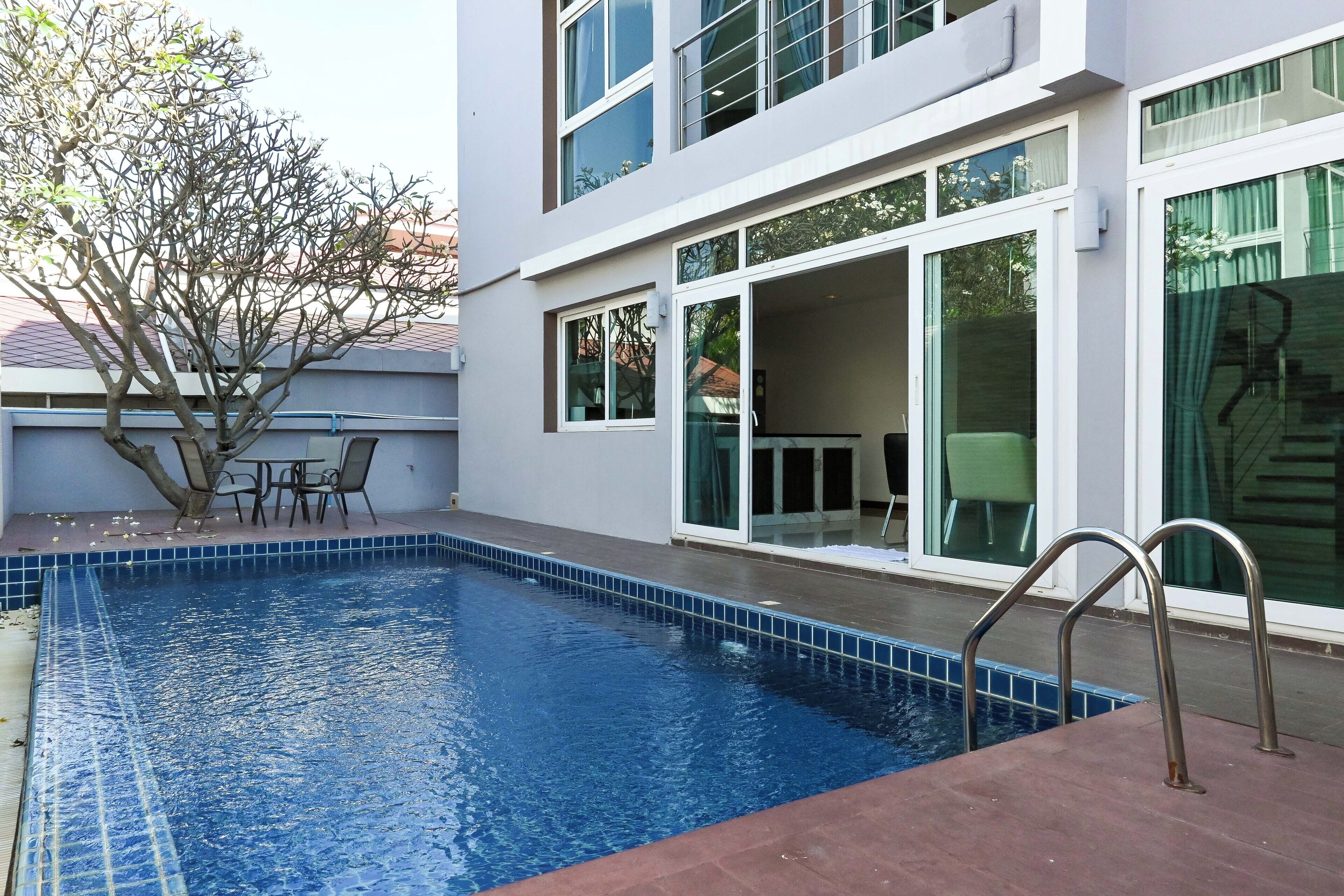 Ein modernes Gebäude mit Swimmingpool, großen Fenstern und einer Terrassenfläche.