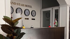 En receptionsdisk med et skilt der står 'RECEPTION' og ure over disken.