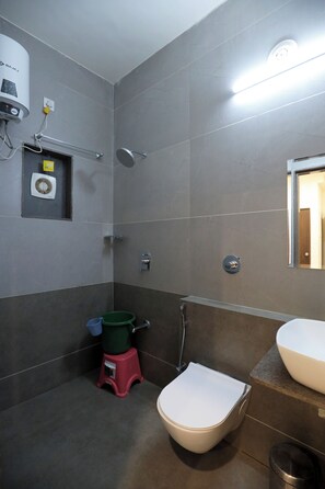 Une salle de bain moderne équipée de toilettes, d’un bidet et d’une douche.