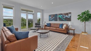 En rummelig stue med en lædersofa, en brun sofa og et rundt sofabord.
