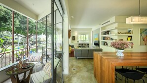 A modern living space with a balcony, a dining area, and a cozy seating area. - Spacious & Green 3BR Apt w Balcony (Tel Aviv)
