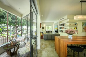 Ein modernes Interieur mit Balkon, Essbereich und Wohnraum mit Sofa und Bücherregalen.