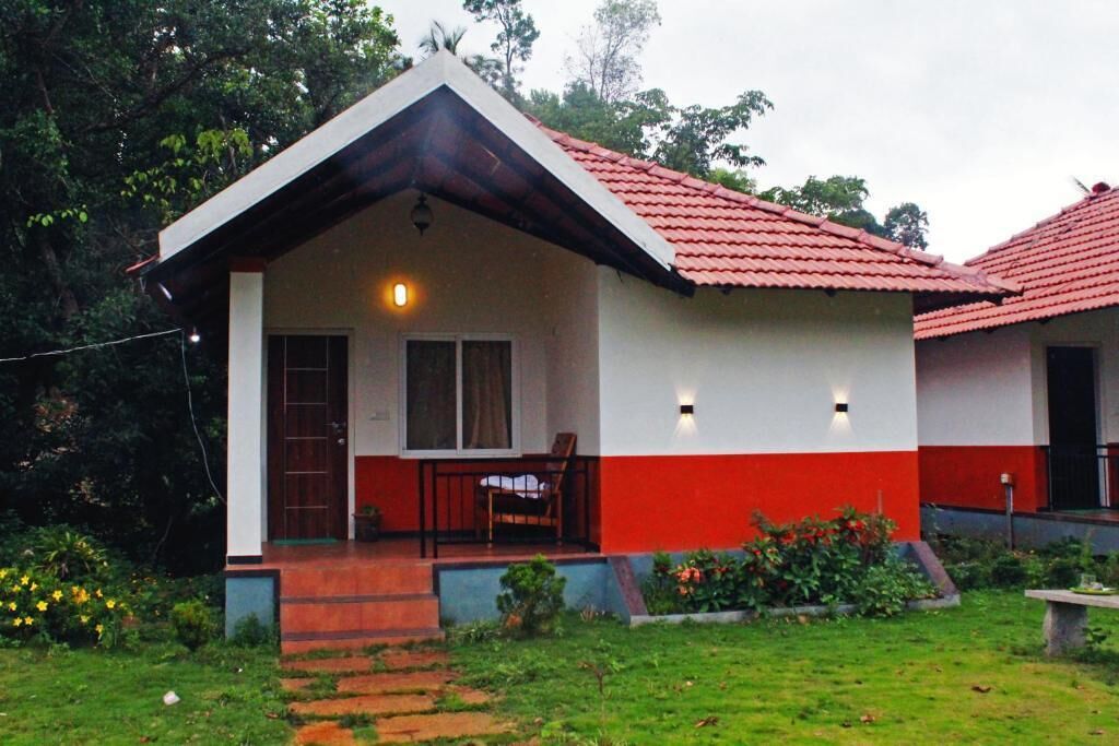 A two-story house with a red roof and white walls.
