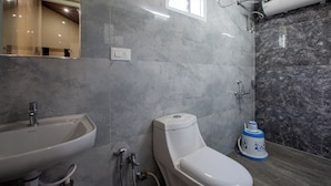 A modern bathroom with a sink, toilet, and shower. - Blossom Inn (Coonoor)