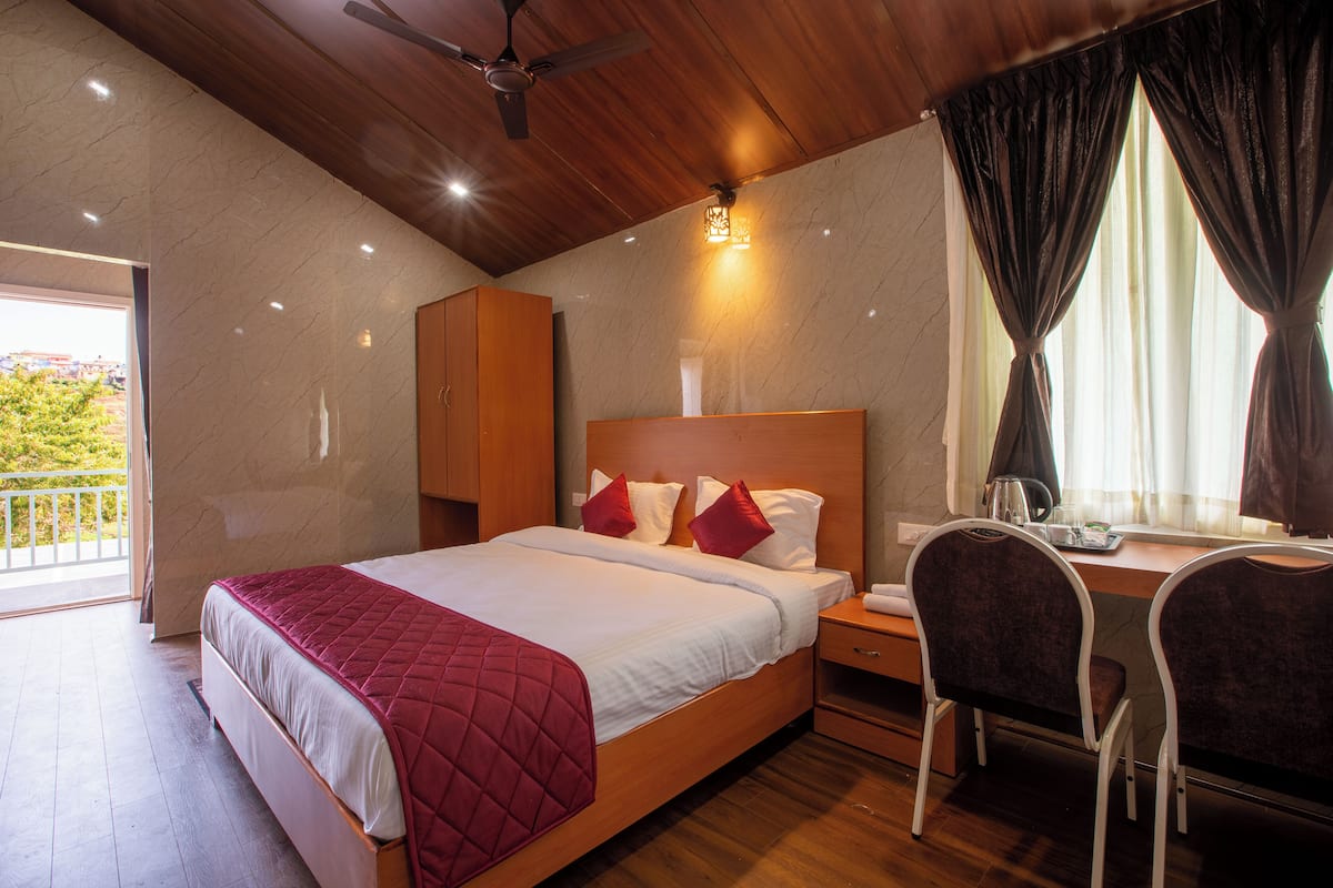 A bedroom with a bed, a desk, and a chair.