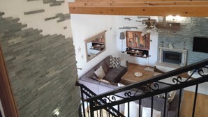 A multi-level interior with a staircase, stone wall, and a living area with a fireplace. - Lavender Hill Hvar (Stari Grad)