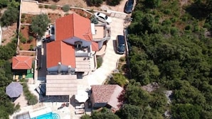 An aerial view of a residential property with multiple buildings, a swimming pool, and surrounding greenery. - Lavender Hill Hvar (Stari Grad)