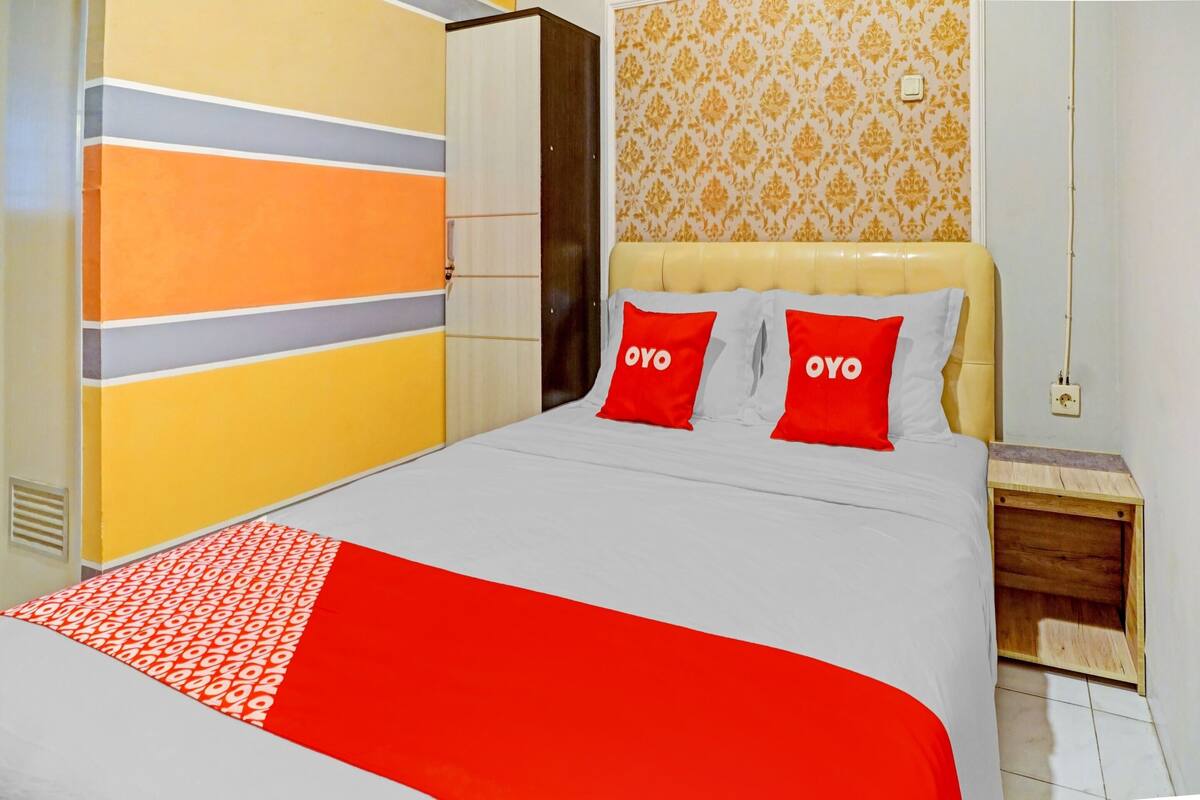 Une chambre d’hôtel avec un lit, une armoire et une table de chevet.