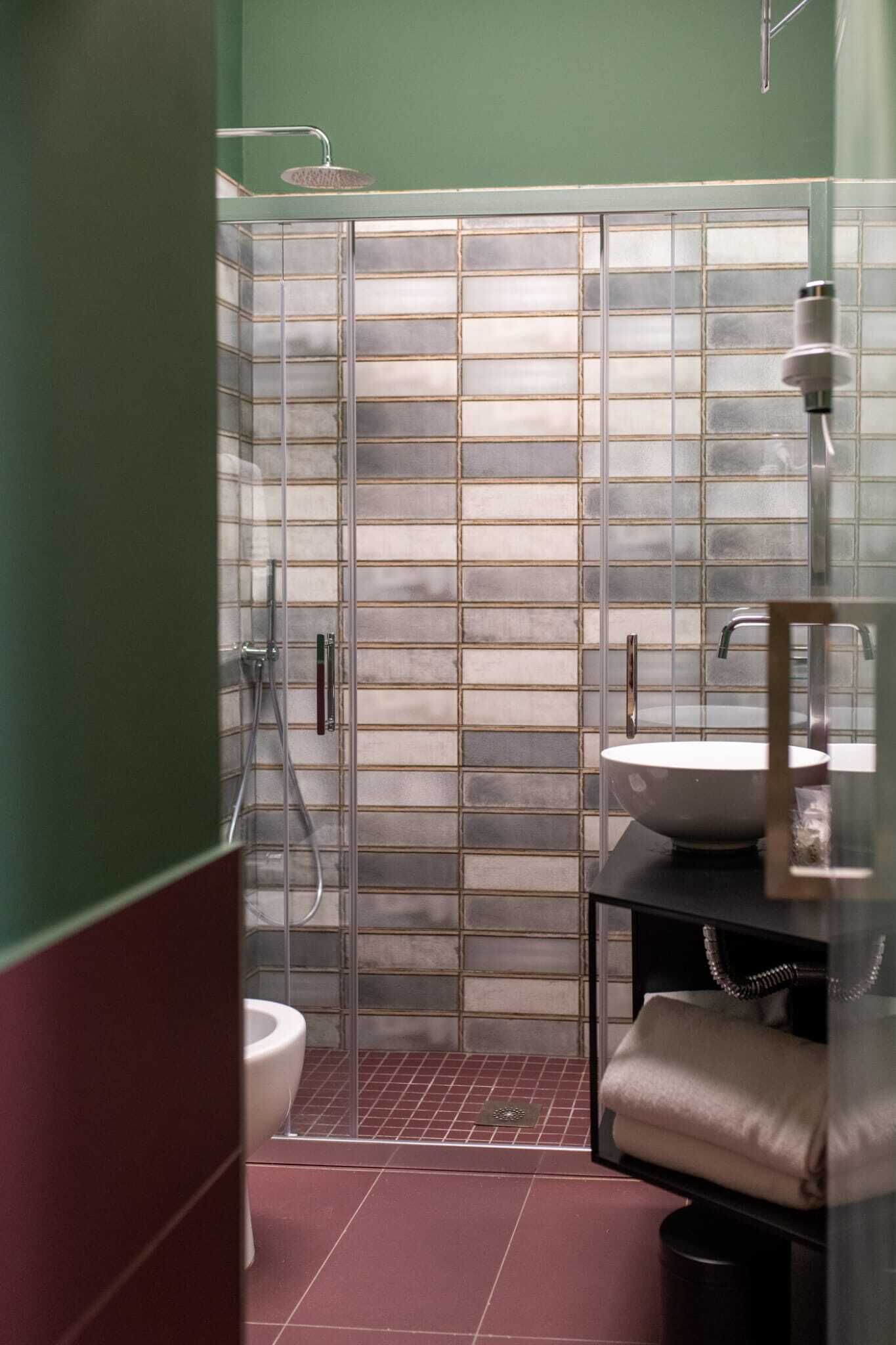 A modern bathroom with a glass shower enclosure, a white sink, and a toilet.