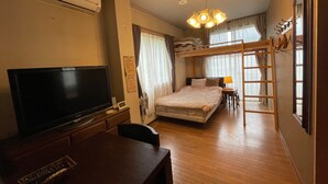 Une chambre d’hôtel équipée d’une télévision, d’un lit superposé, de meubles en bois et d’une échelle.