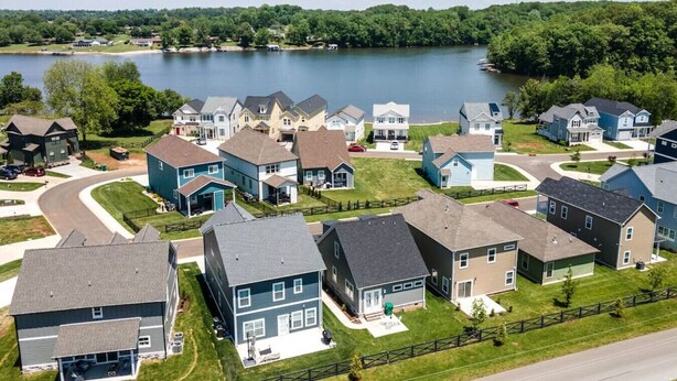 Un quartier résidentiel avec des maisons, un lac et une route.