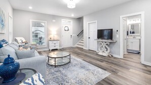 Un salon moderne avec un canapé, une table basse et un téléviseur.