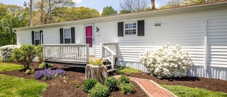 A single-story white house with a front porch, a mailbox, and a number '715' on the door.