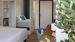A modern hotel room with a bed, a desk, a wardrobe, and a door with a 'DO NOT ENTER' sign. - Kairos Tropea (Tropea)