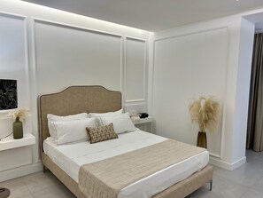 A neatly arranged bedroom with a large bed, bedside tables, and a decorative vase. - Kairos Tropea (Tropea)