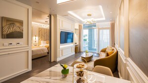 A hotel room with a bed, a TV, a dining area with a marble table, and a sofa. - The Siena Resort (Seogwipo)