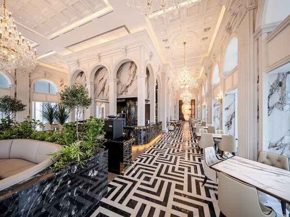 A luxurious hotel lobby with marble flooring, elegant chandeliers, and a seating area with a sofa and plants. - The Siena Resort (Seogwipo)