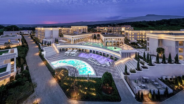 A modern hotel with a large pool area, multiple buildings, and landscaped gardens. - The Siena Resort (Seogwipo)