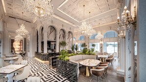 A luxurious lobby with marble flooring, elegant chandeliers, and a seating area with a sofa and tables. - The Siena Resort (Seogwipo)