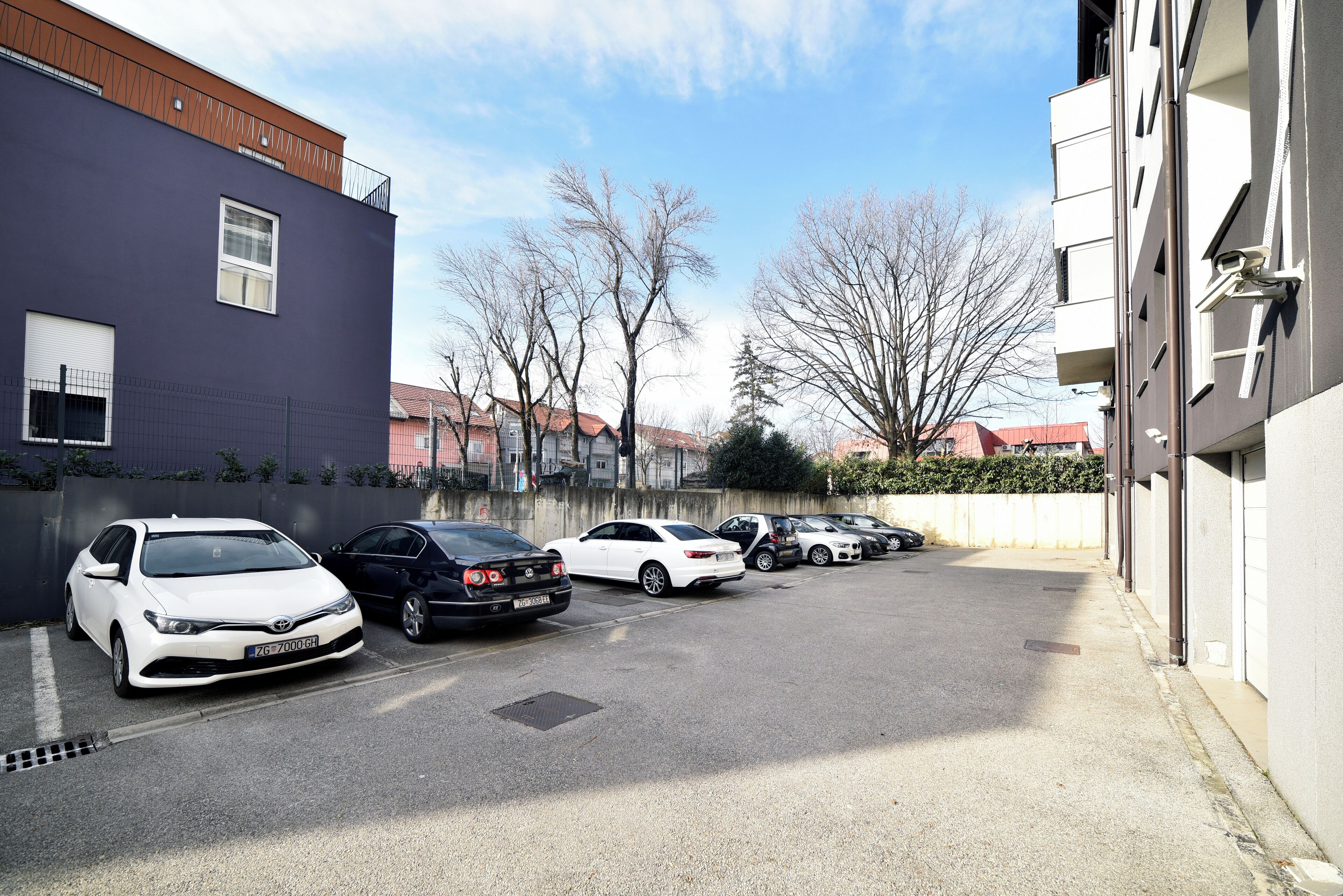 Un parcheggio con diverse automobili parcheggiate in un contesto urbano.