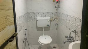 Un baño pequeño con inodoro, bidé y lavamanos.