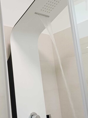 Una ducha moderna con diseño curvo y panel transparente.