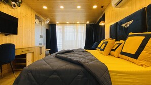 A room with a bed, a desk, a chair, and a window with curtains. - Clarence Cottage (Dehradun)