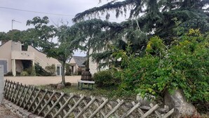 Un barrio residencial con una valla de madera, un muro de piedra y un edificio con techo inclinado.