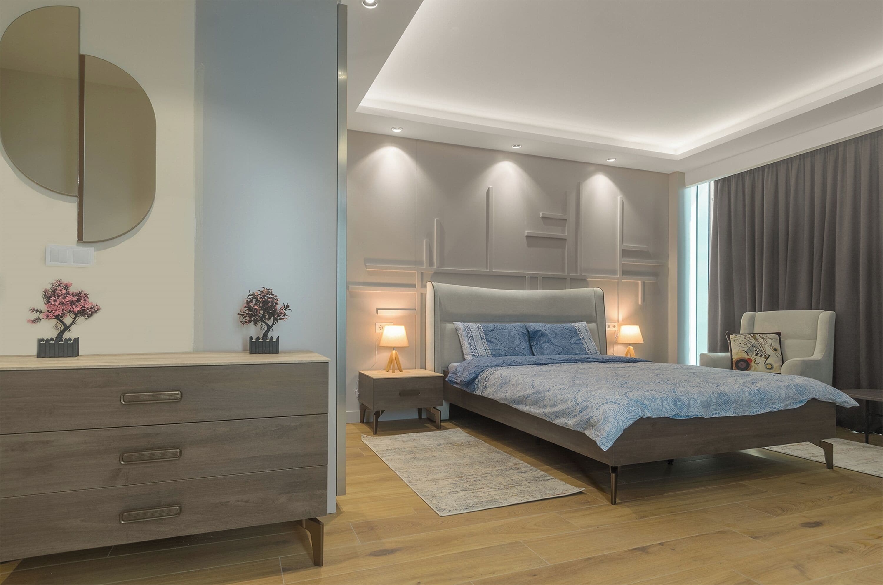 A modern bedroom with a bed, bedside tables, a dresser, a mirror, and a chair.