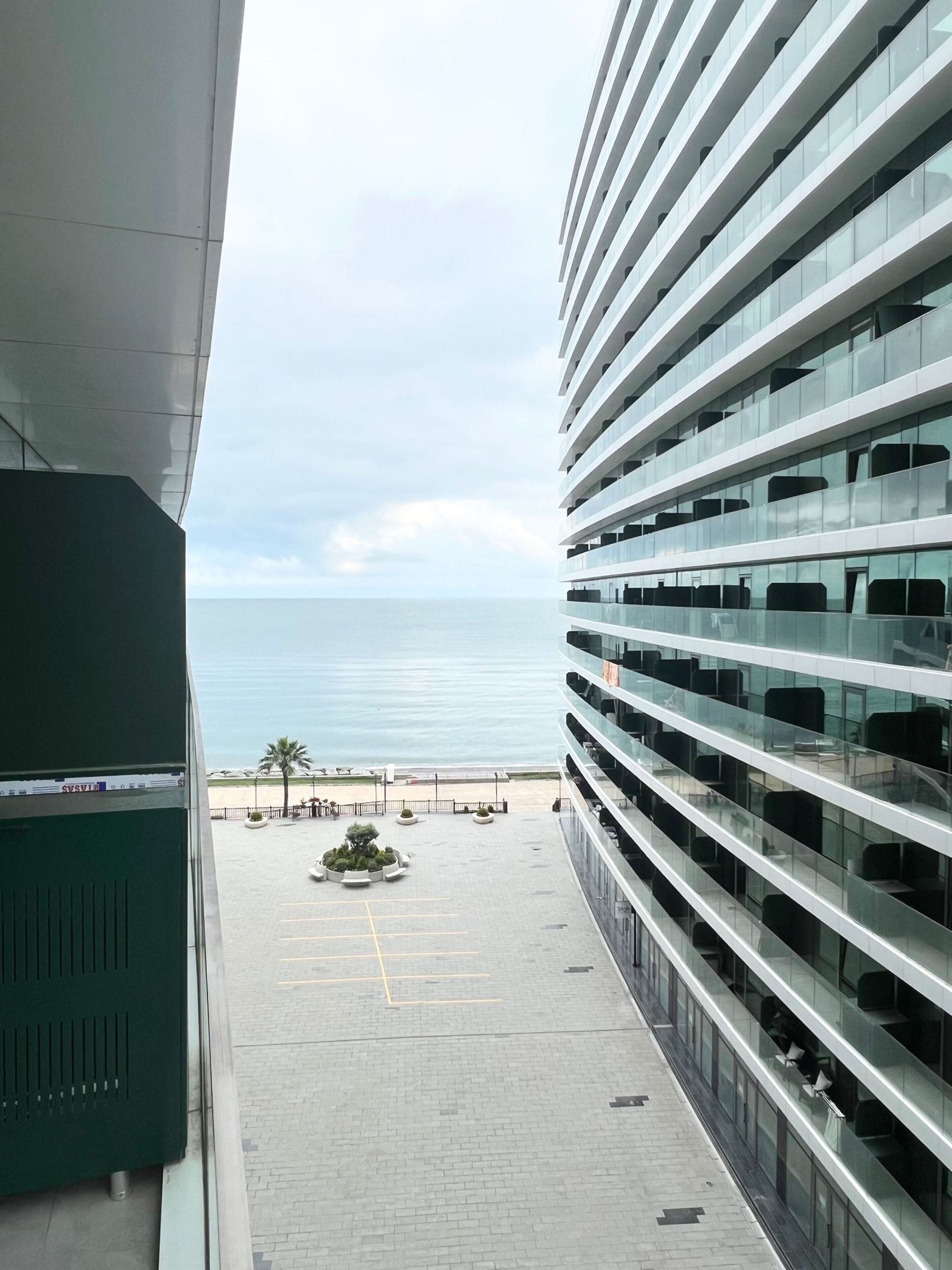 Un edificio moderno con fachada de vidrio que da a la playa.