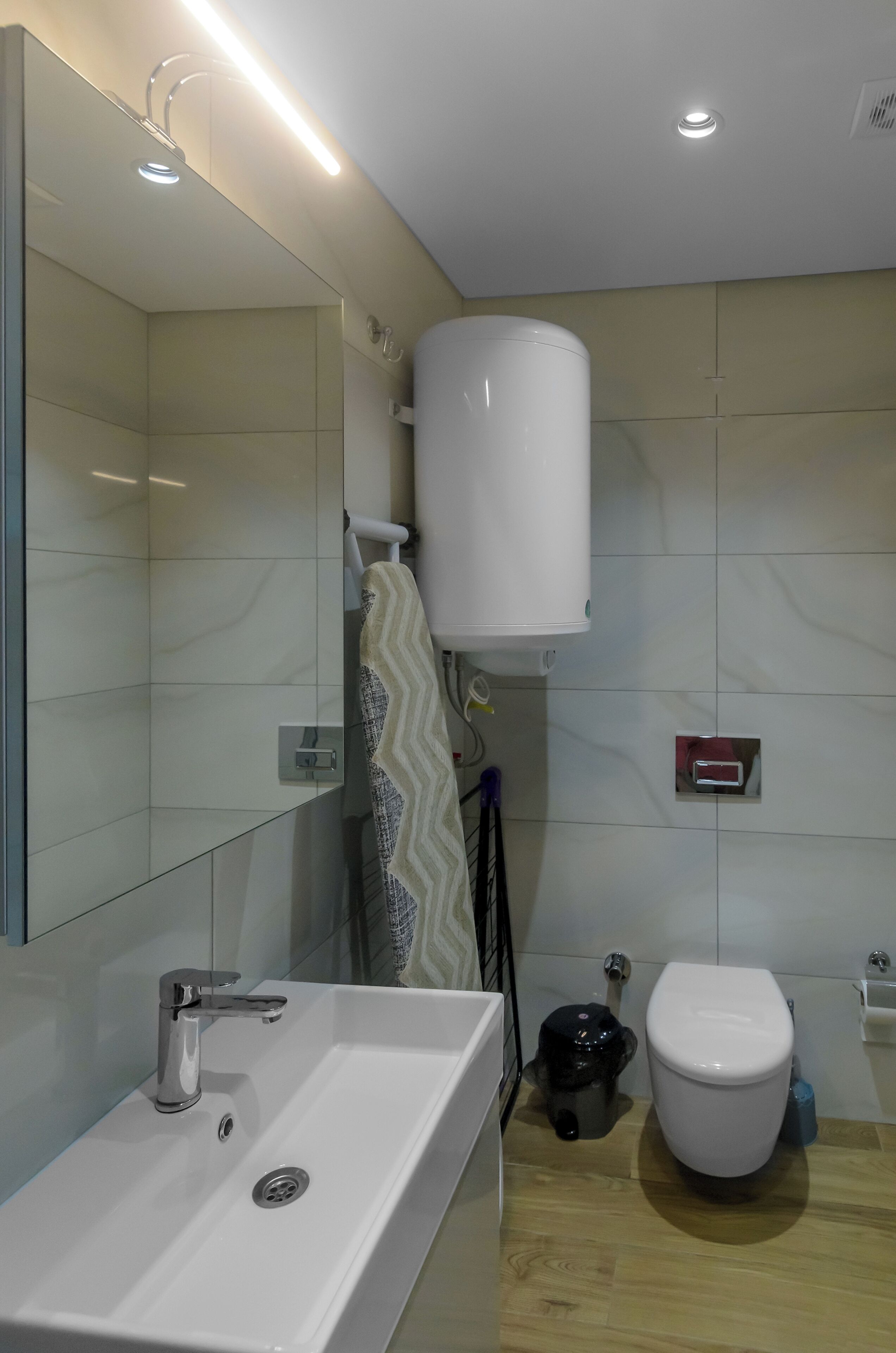A modern bathroom with a white sink, a toilet, and a shower area.
